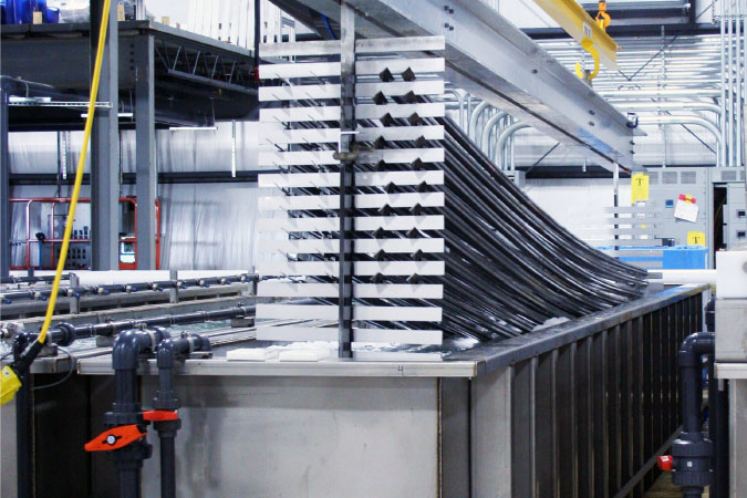 Anodizing process; metal being dipped in anodizing tank